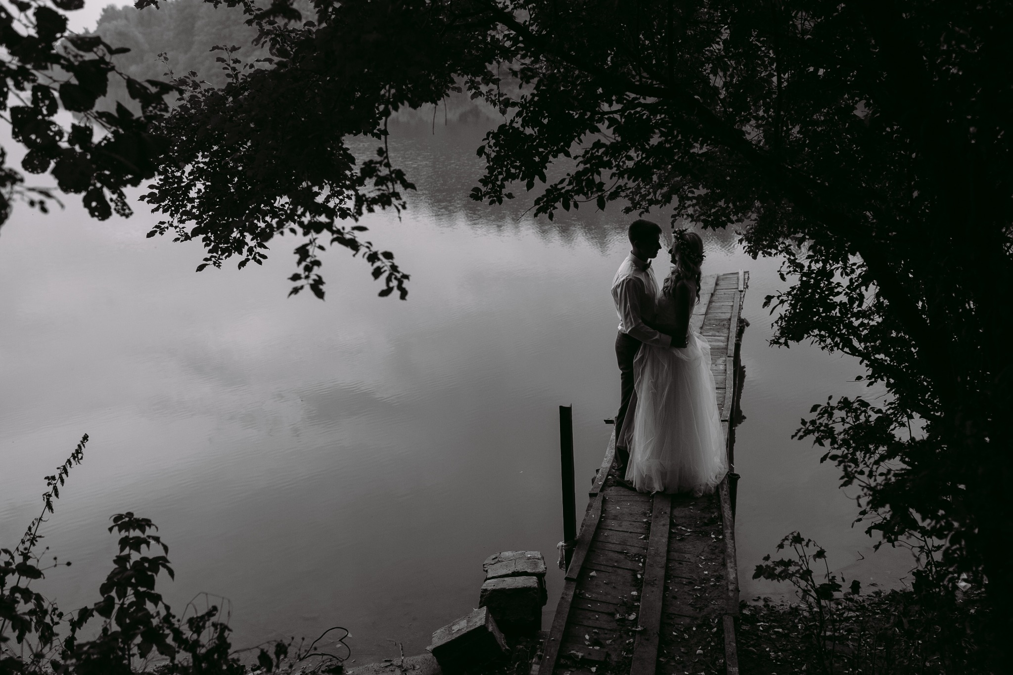 Romantic couple embracing on a dock by a calm lake
