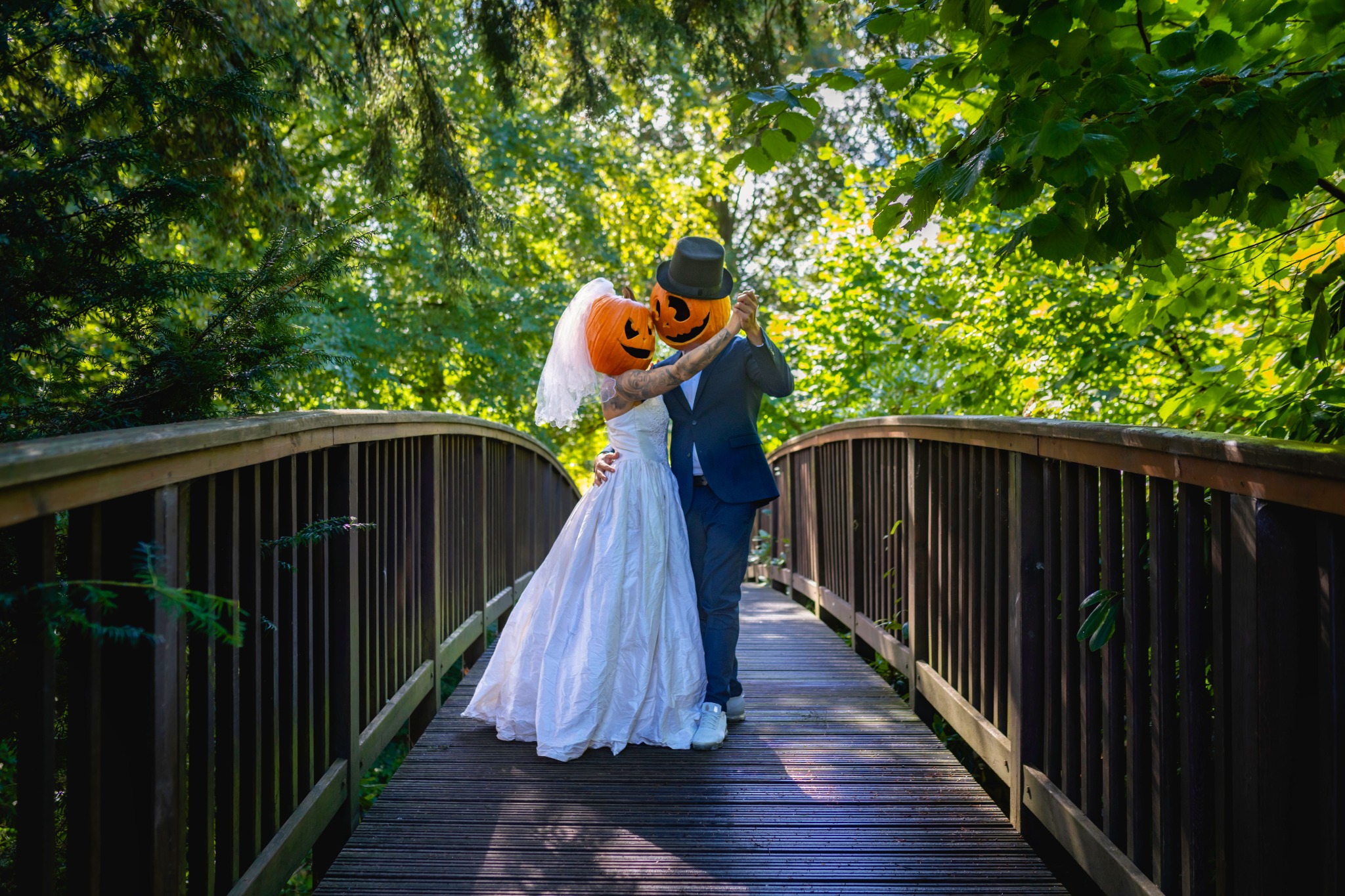Playful costumed wedding couple on a bridge