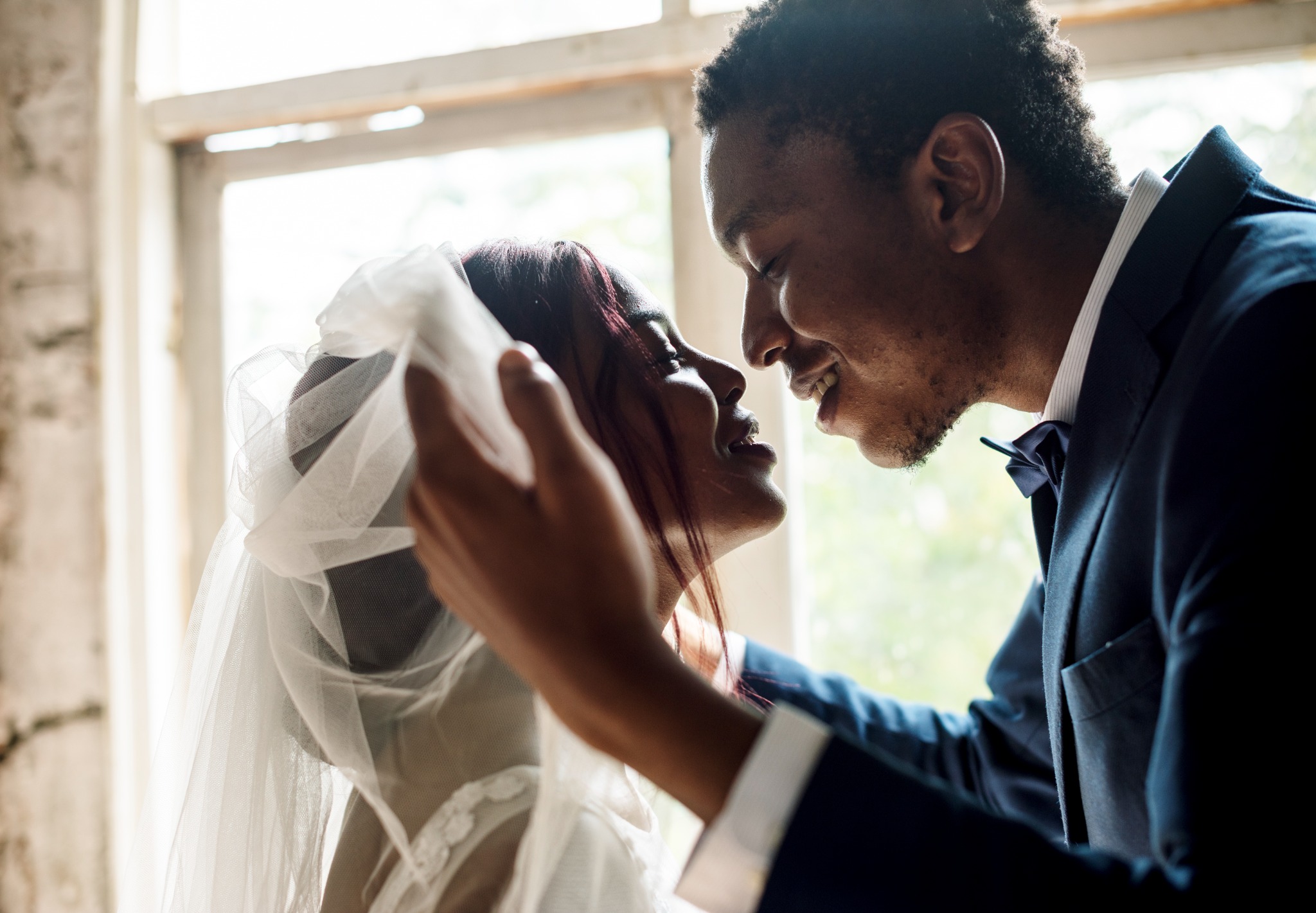 Bride and groom sharing a quiet moment by a window